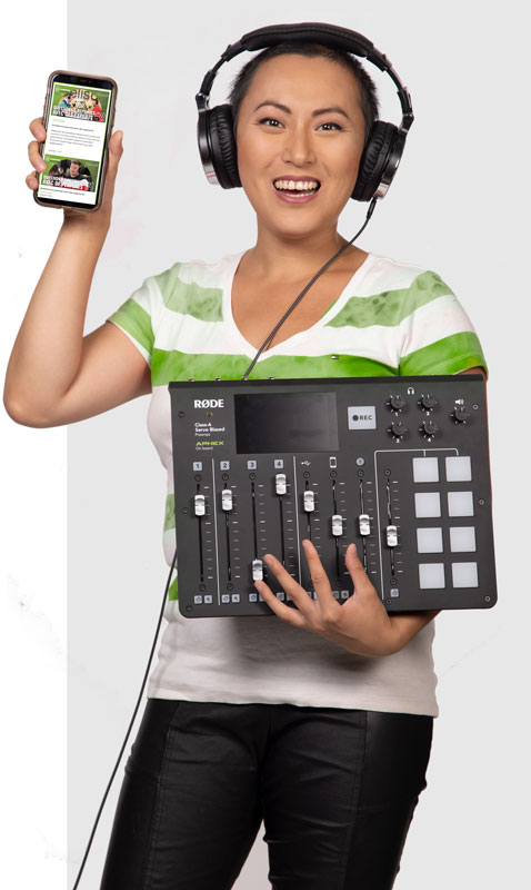 Femme souriante portant des écouteurs et tenant une console de mixage Rode d'une main et un téléphone affichant une application de Delisoft de l'autre.